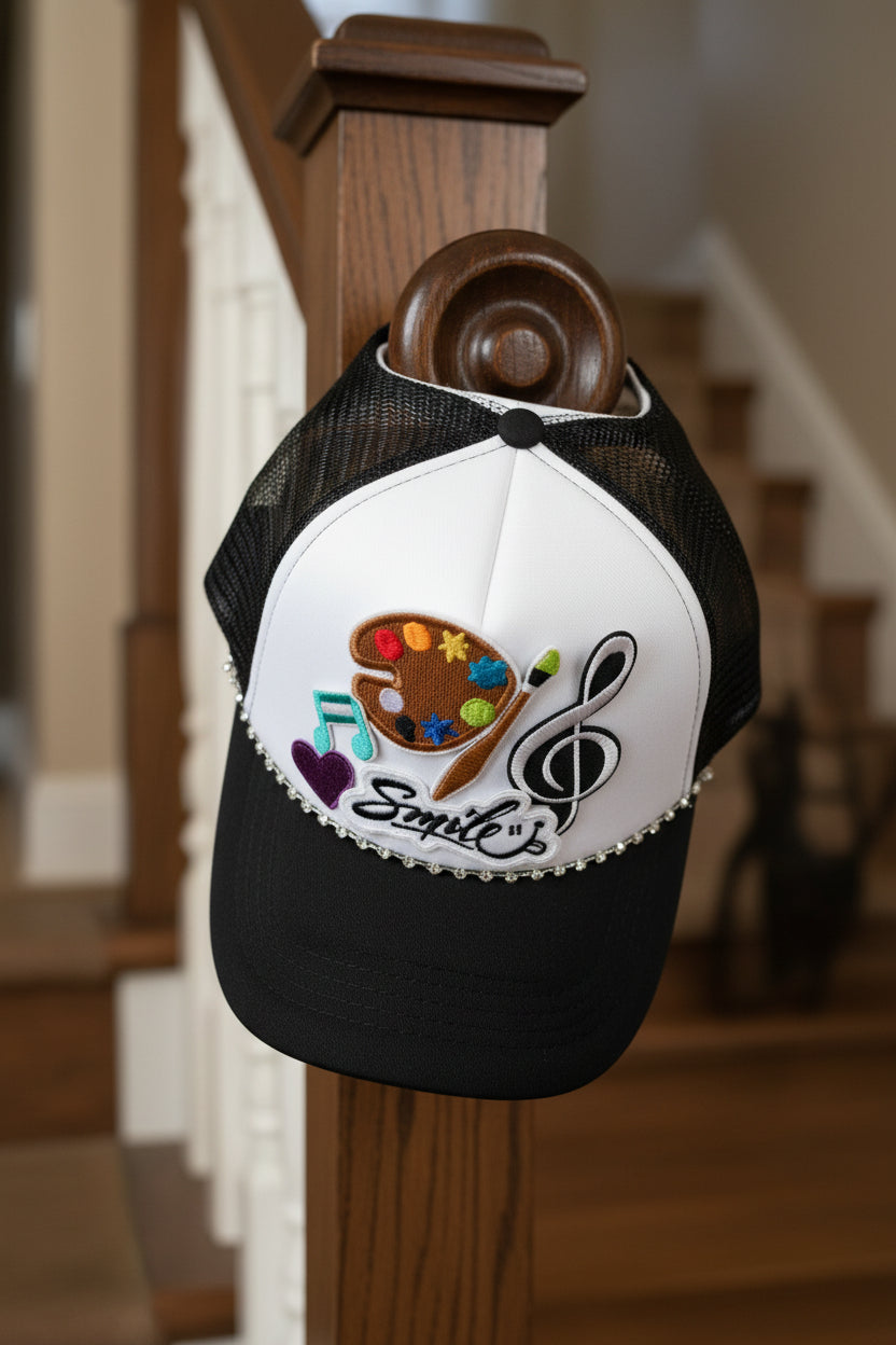 Black and white cap with colorful designs on a wooden stair rail