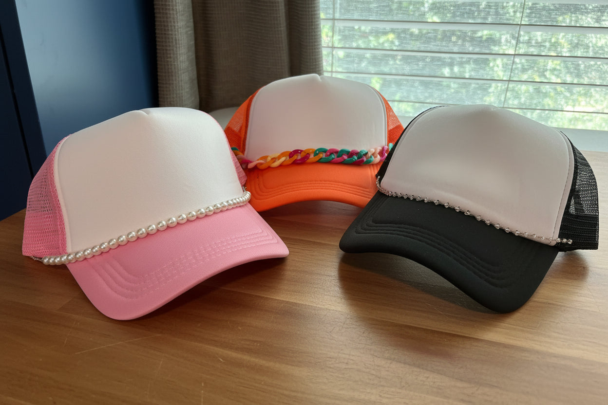 Three colorful caps with decorative elements on a surface.